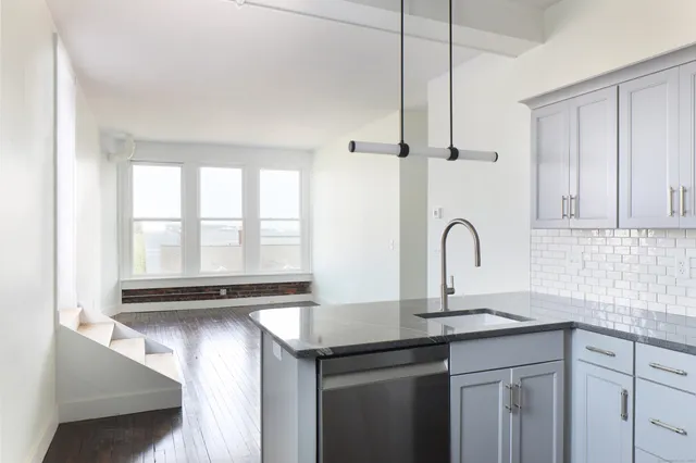 a kitchen with stainless steel appliances granite countertop a sink and a stove