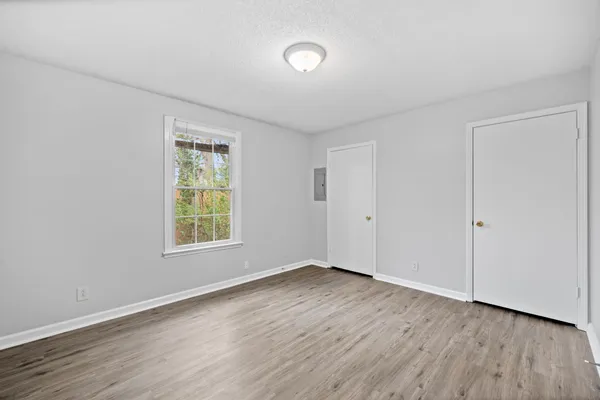 an empty room with wooden floor and windows