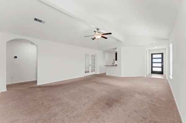 a view of a big room with chandelier fan and windows