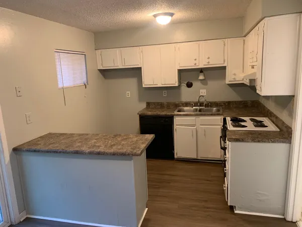 a kitchen with granite countertop wood cabinets sink and stainless steel appliances