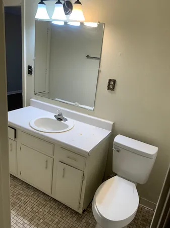 a white toilet sitting next to a bathroom sink