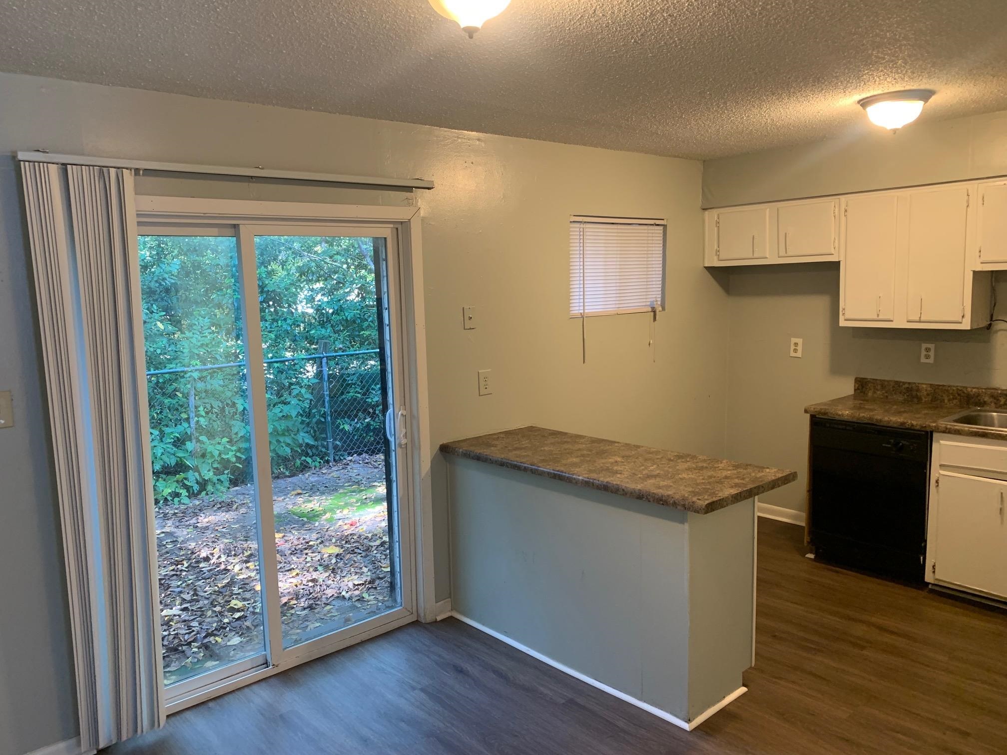 677 Miles, Unit 677 Memphis, TN 38111 - Photo 8 of 17 a kitchen with granite countertop wooden cabinets and a large window