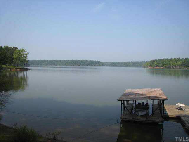 311 Kerr Lake Road Henderson, NC 27537 - Photo 3 of 10 a view of a lake with table and chairs next to a yard