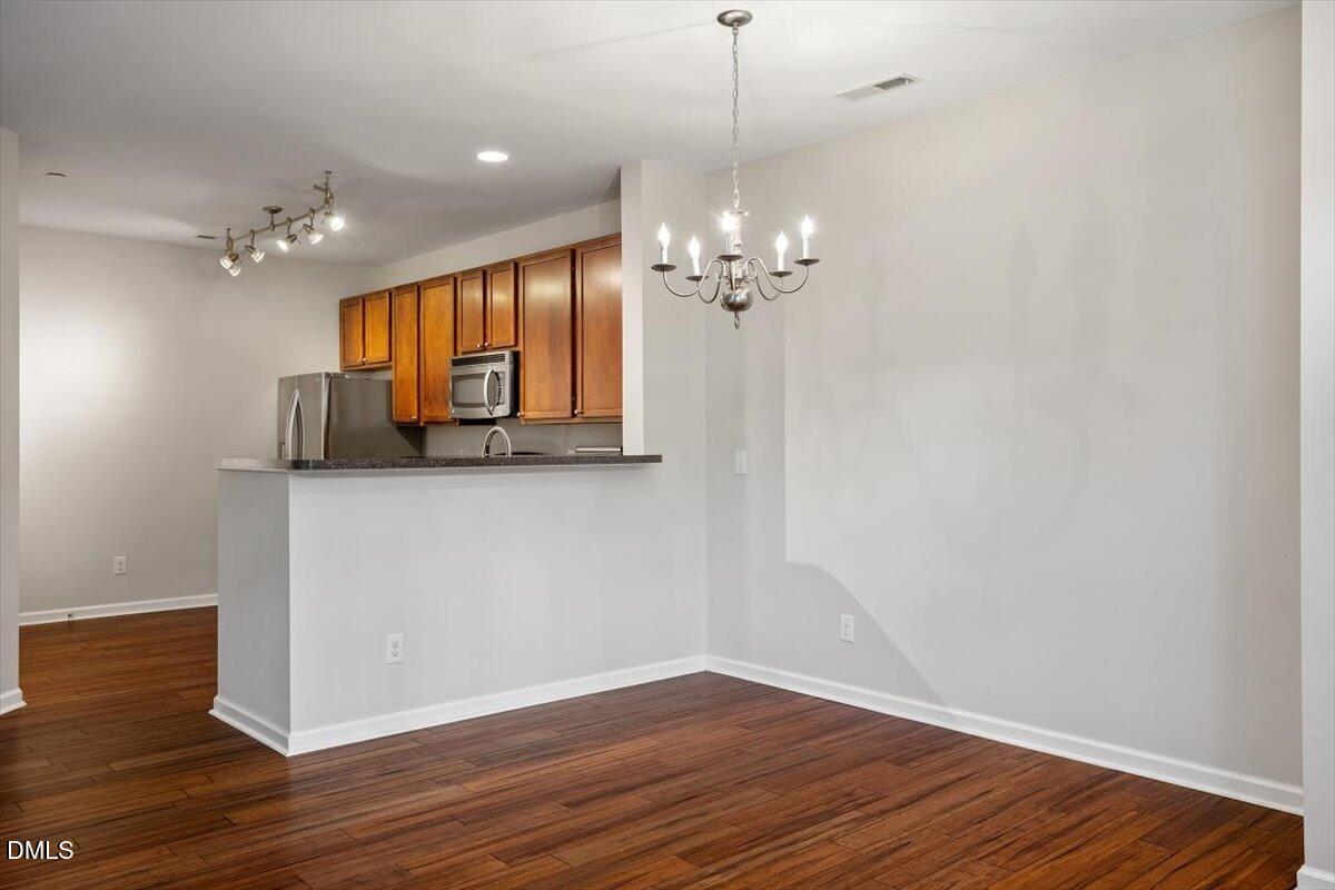 1120 Renewal Place, Unit 113 Raleigh, NC 27603 - Photo 14 of 38 a view of a room with wooden floor and chandelier