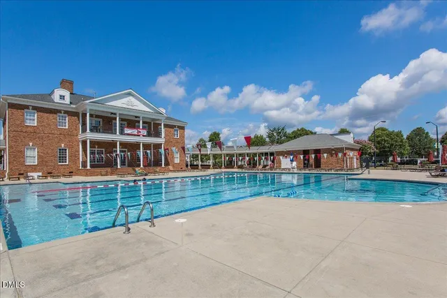 a view of a house with pool and chairs