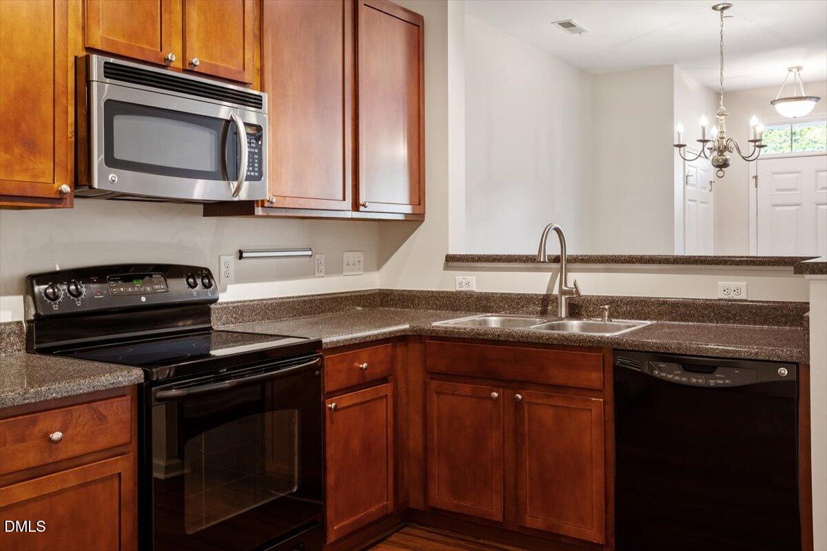1120 Renewal Place, Unit 113 Raleigh, NC 27603 - Photo 5 of 38 a kitchen with stainless steel appliances granite countertop a sink stove and microwave