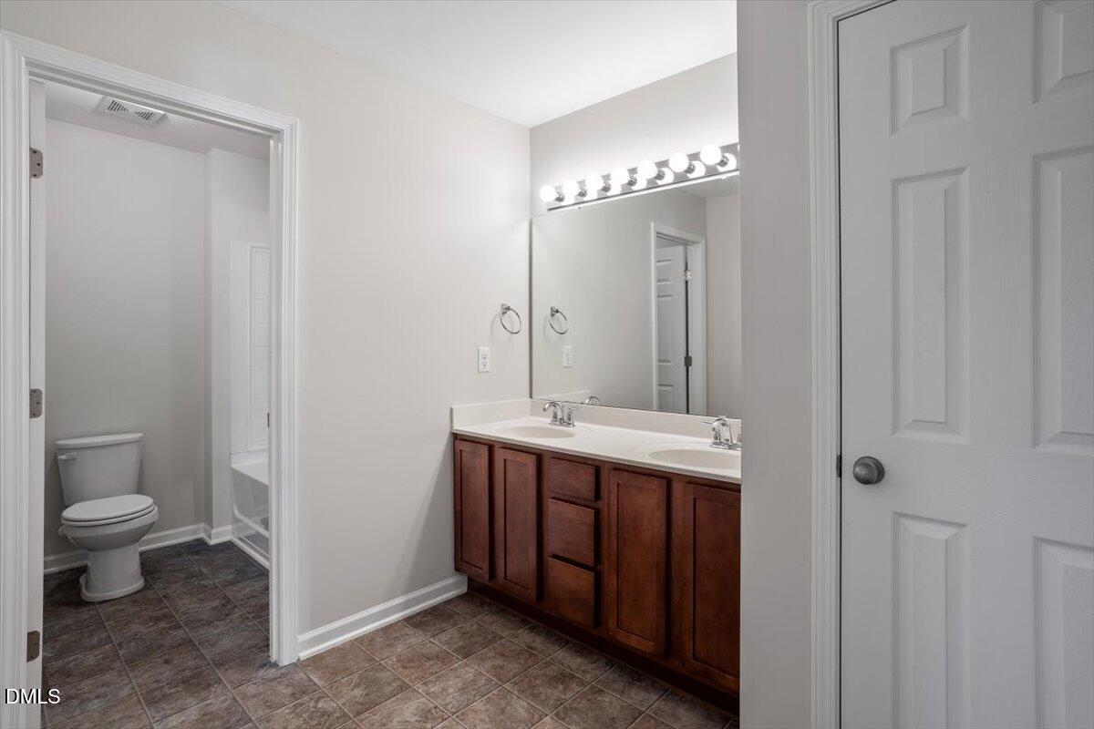 1120 Renewal Place, Unit 113 Raleigh, NC 27603 - Photo 7 of 38 a bathroom with a double vanity sink and a toilet