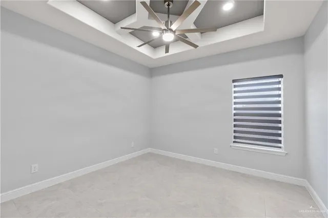 en empty room with windows and ceiling fan