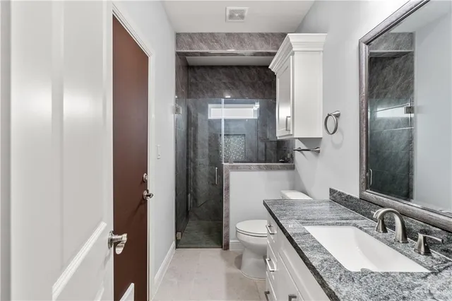 a bathroom with a granite countertop sink toilet and shower