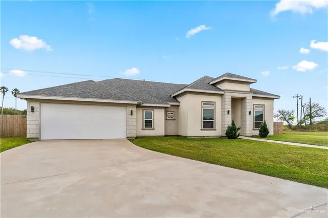 a front view of a house with a yard and garage