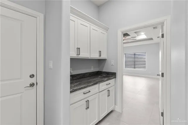 a kitchen with granite countertop white cabinets and sink