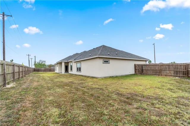 a view of an empty room with kitchen and stove