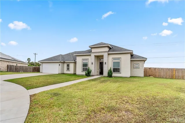 a view of a house with a big yard and large trees