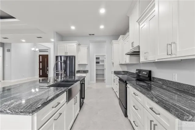 a kitchen with stainless steel appliances granite countertop a sink stove and refrigerator