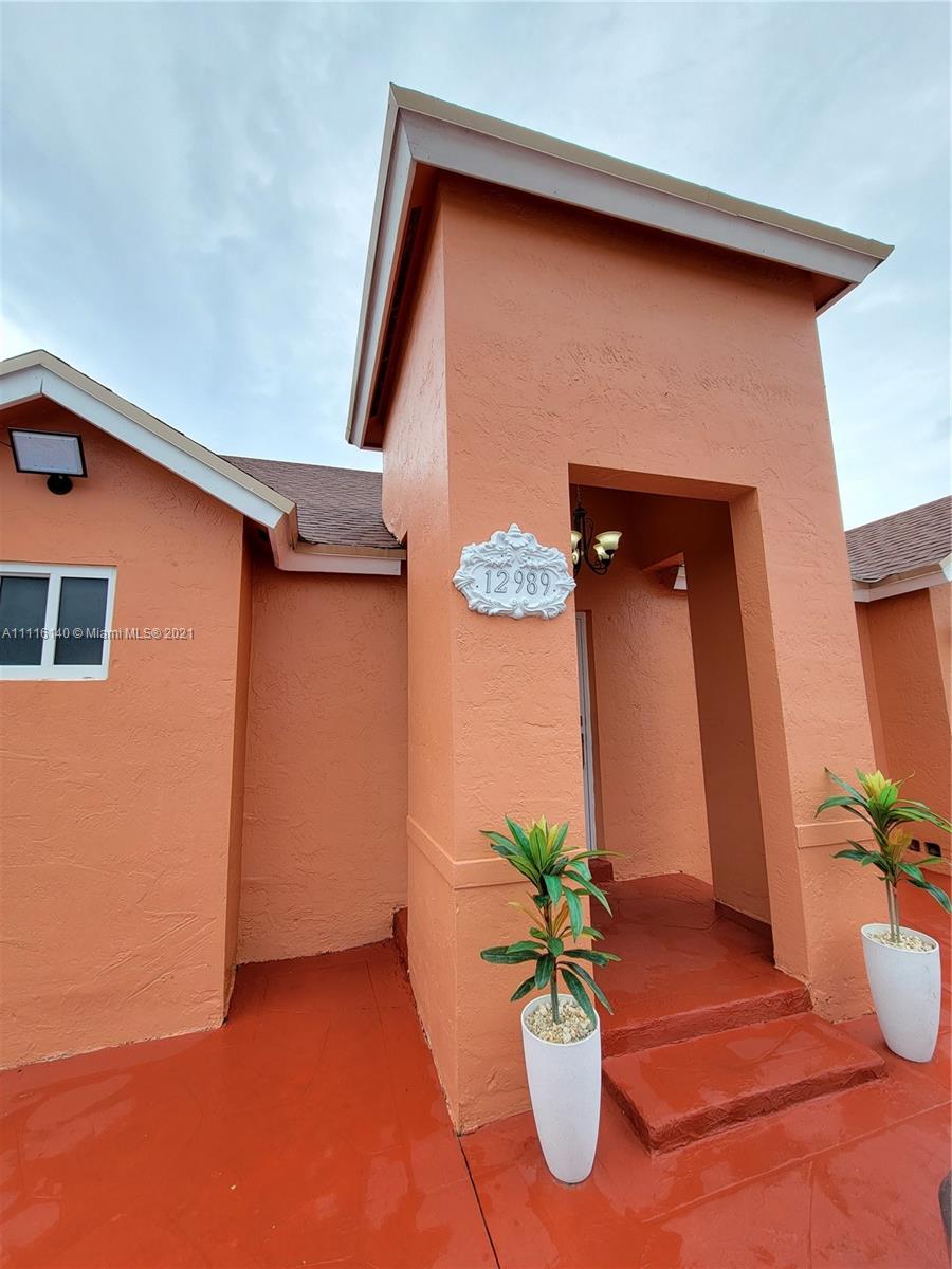 12989 Southwest 251st Terrace Homestead, FL 33032 - Photo 2 of 28 a front view of a house with potted plants