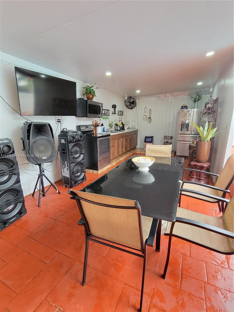 12989 Southwest 251st Terrace Homestead, FL 33032 - Photo 12 of 28 a view of a dining room with furniture and a flat screen tv
