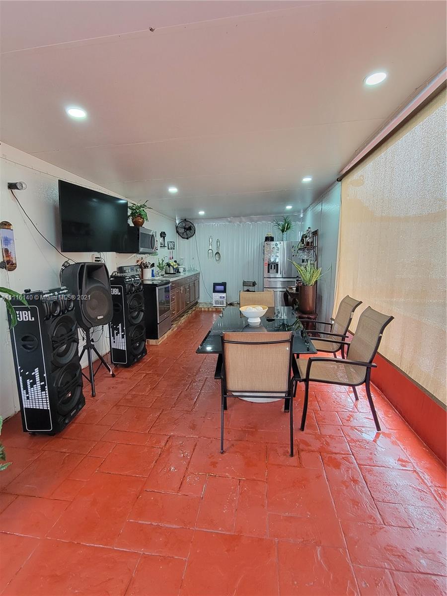 12989 Southwest 251st Terrace Homestead, FL 33032 - Photo 13 of 28 a living room with furniture a flat screen tv and a table