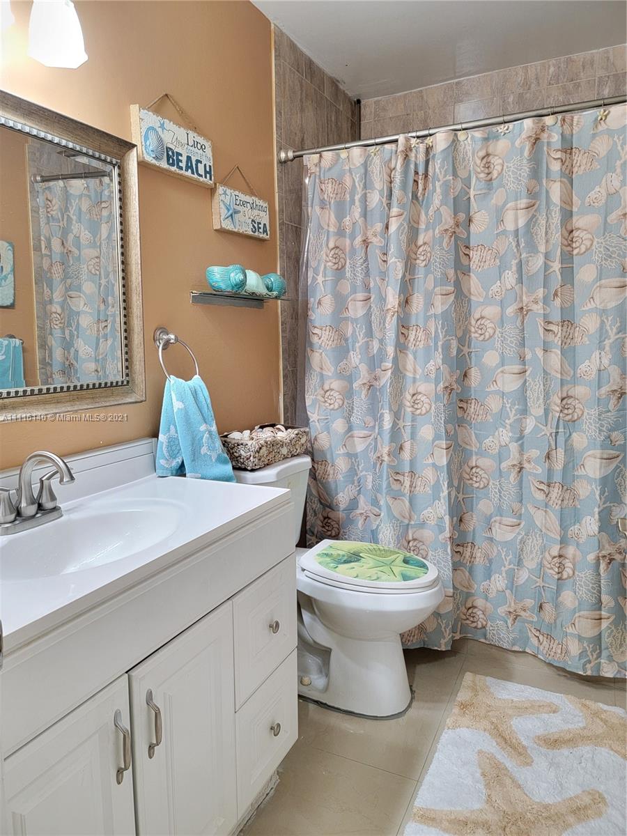 12989 Southwest 251st Terrace Homestead, FL 33032 - Photo 19 of 28 a bathroom with a granite countertop sink a toilet and a shower