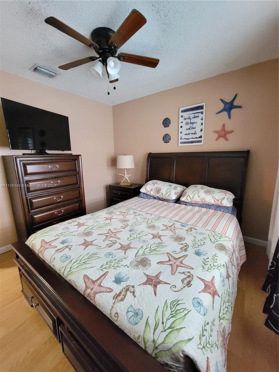 12989 Southwest 251st Terrace Homestead, FL 33032 - Photo 21 of 28 a bedroom with a bed and a flat screen tv