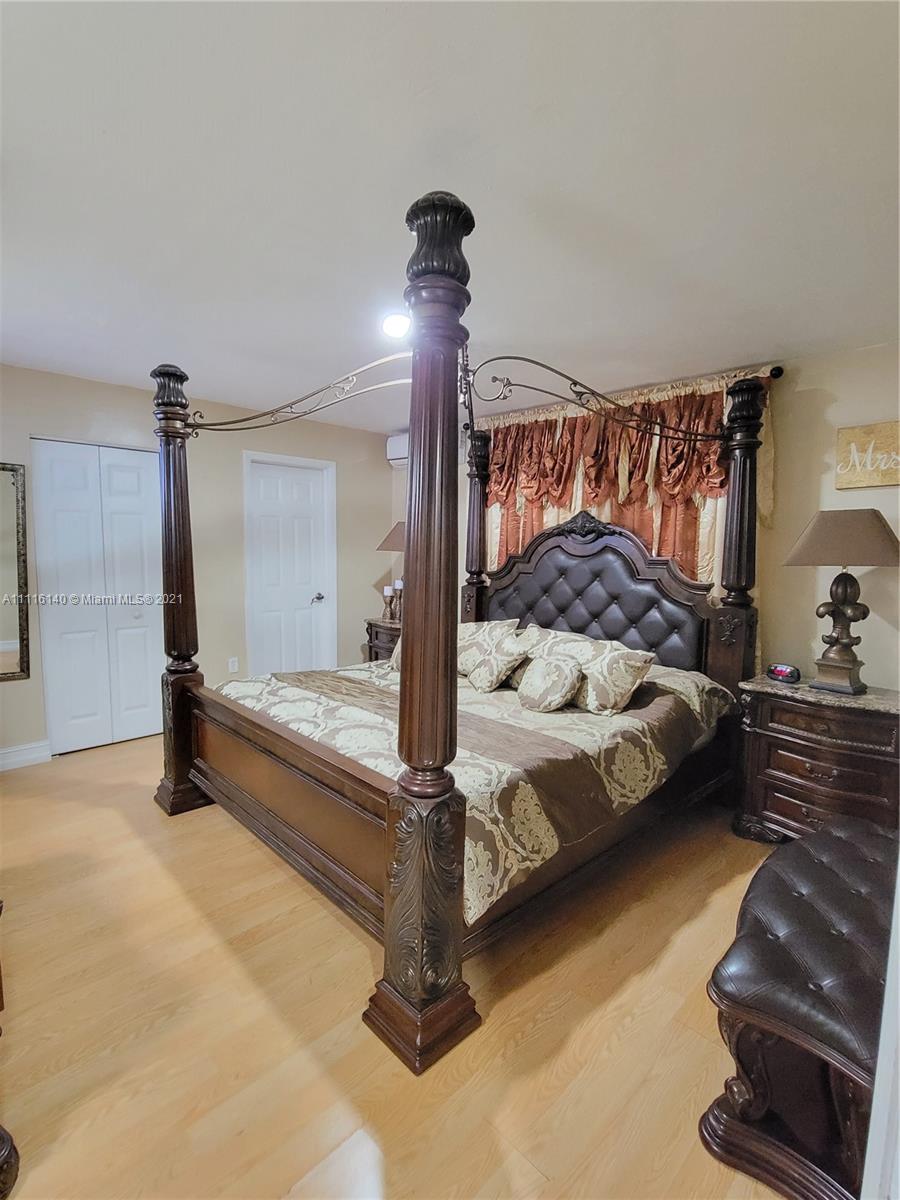 12989 Southwest 251st Terrace Homestead, FL 33032 - Photo 22 of 28 a bedroom with a bed and a chandelier