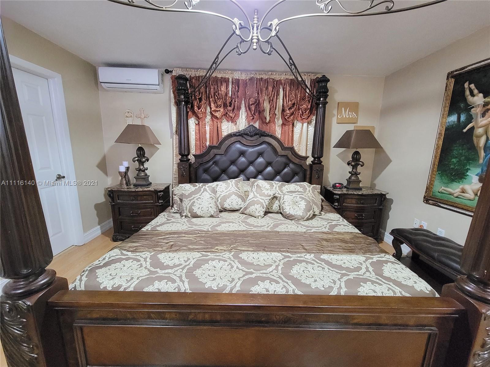12989 Southwest 251st Terrace Homestead, FL 33032 - Photo 23 of 28 a bedroom with a bed and dresser with mirror