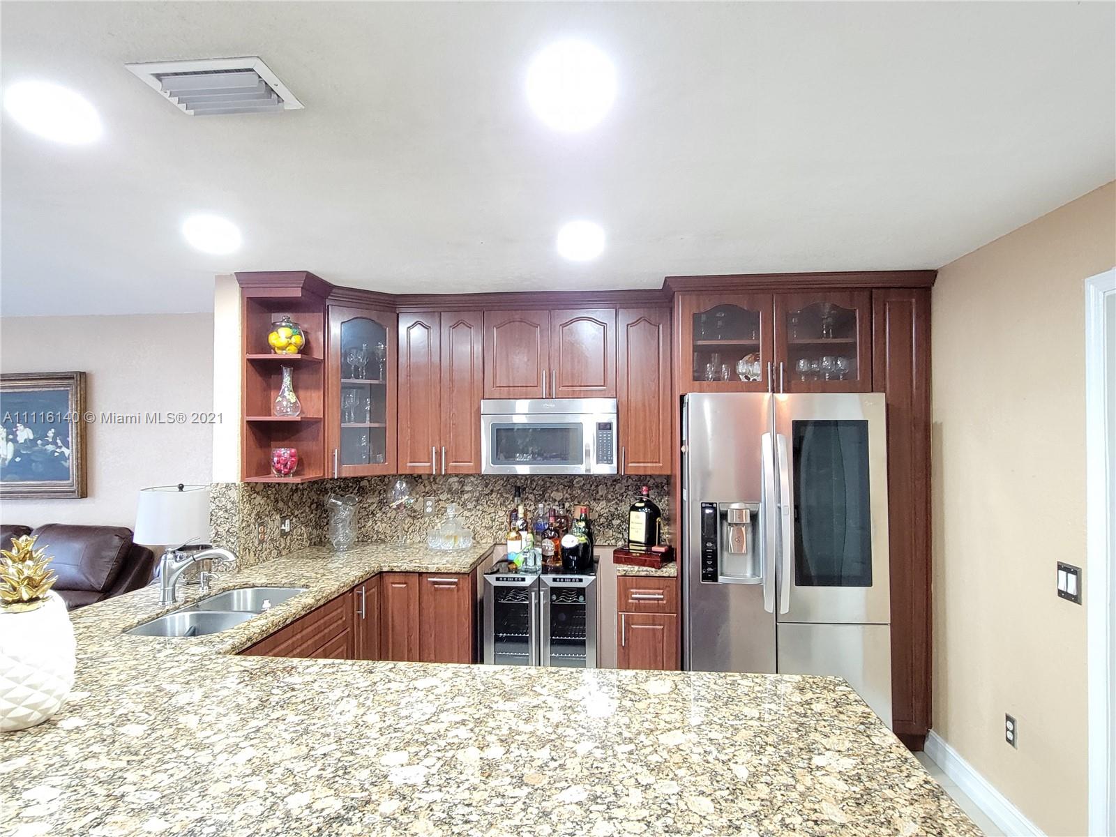 12989 Southwest 251st Terrace Homestead, FL 33032 - Photo 6 of 28 a kitchen with stainless steel appliances kitchen island granite countertop a refrigerator and a sink