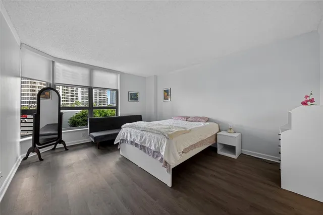 a bedroom with a bed window and wooden floor