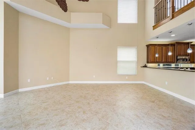 a view of an empty room with kitchen view and a window