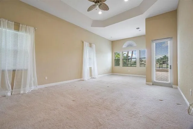an empty room with wooden floor cabinet and windows