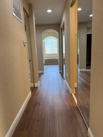 a view of a hallway view with wooden floor and staircase