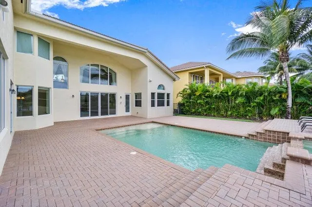 a view of a white house with a yard and potted plants
