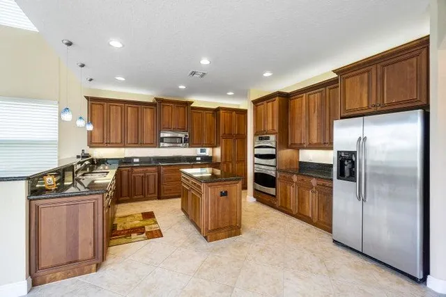a kitchen with stainless steel appliances granite countertop a refrigerator stove top oven and sink