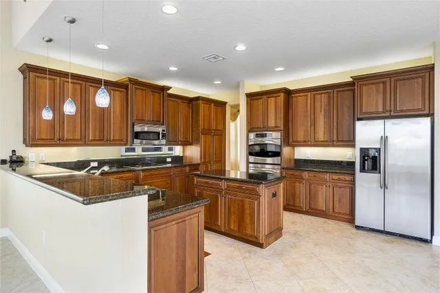 a kitchen with stainless steel appliances granite countertop a stove refrigerator sink and cabinets