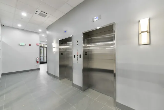 a view of a refrigerator in kitchen and an empty room