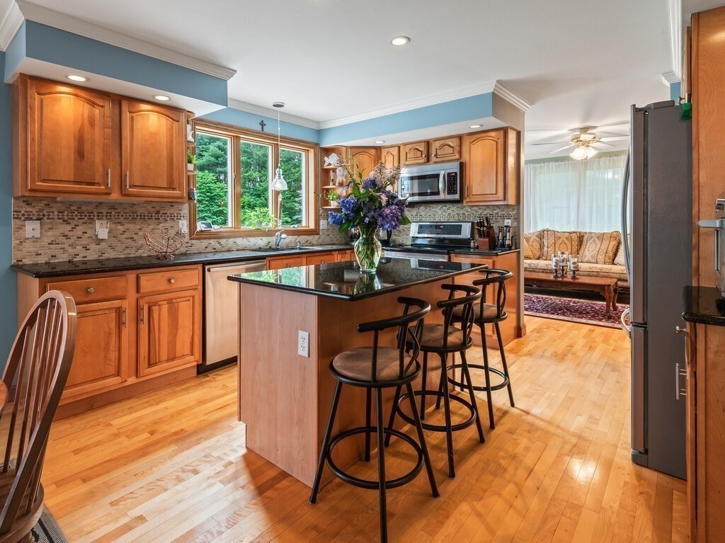 9 Santom Street Auburn, MA 01501 - Photo 7 of 42 a dining room with stainless steel appliances granite countertop a stove top oven a dining table and chairs with wooden floor