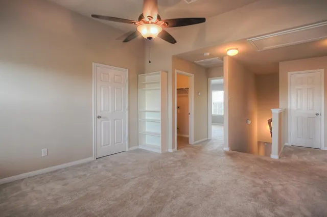 an empty room with closet and a chandelier fan