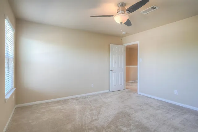 an empty room with closet and a chandelier fan