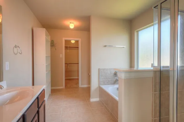 a bathroom with a tub shower and sink