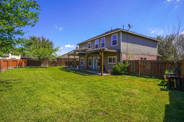 a view of a house with backyard and sitting area