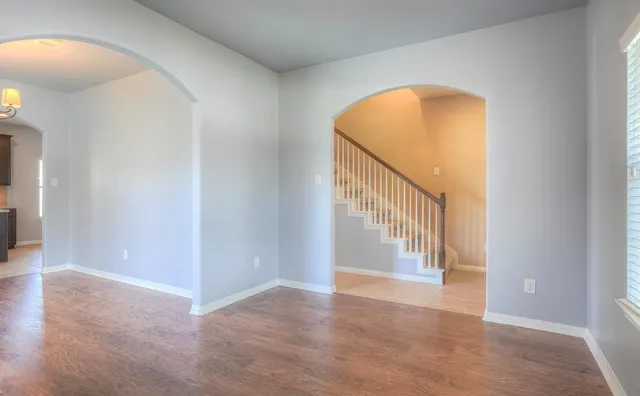 a view of an empty room with wooden floor