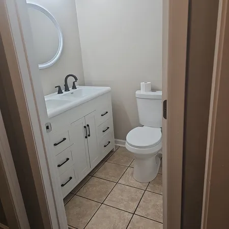 a bathroom with a toilet a sink and mirror