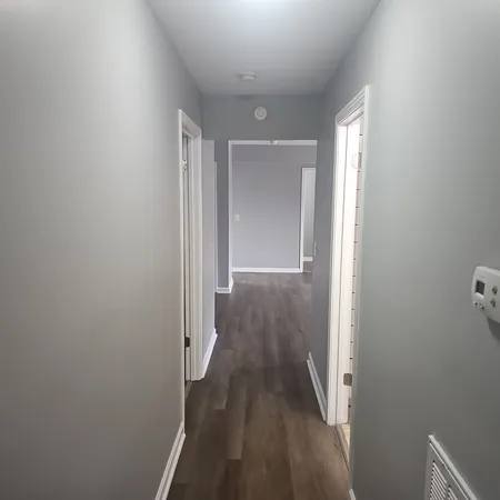 a view of a hallway with wooden floor