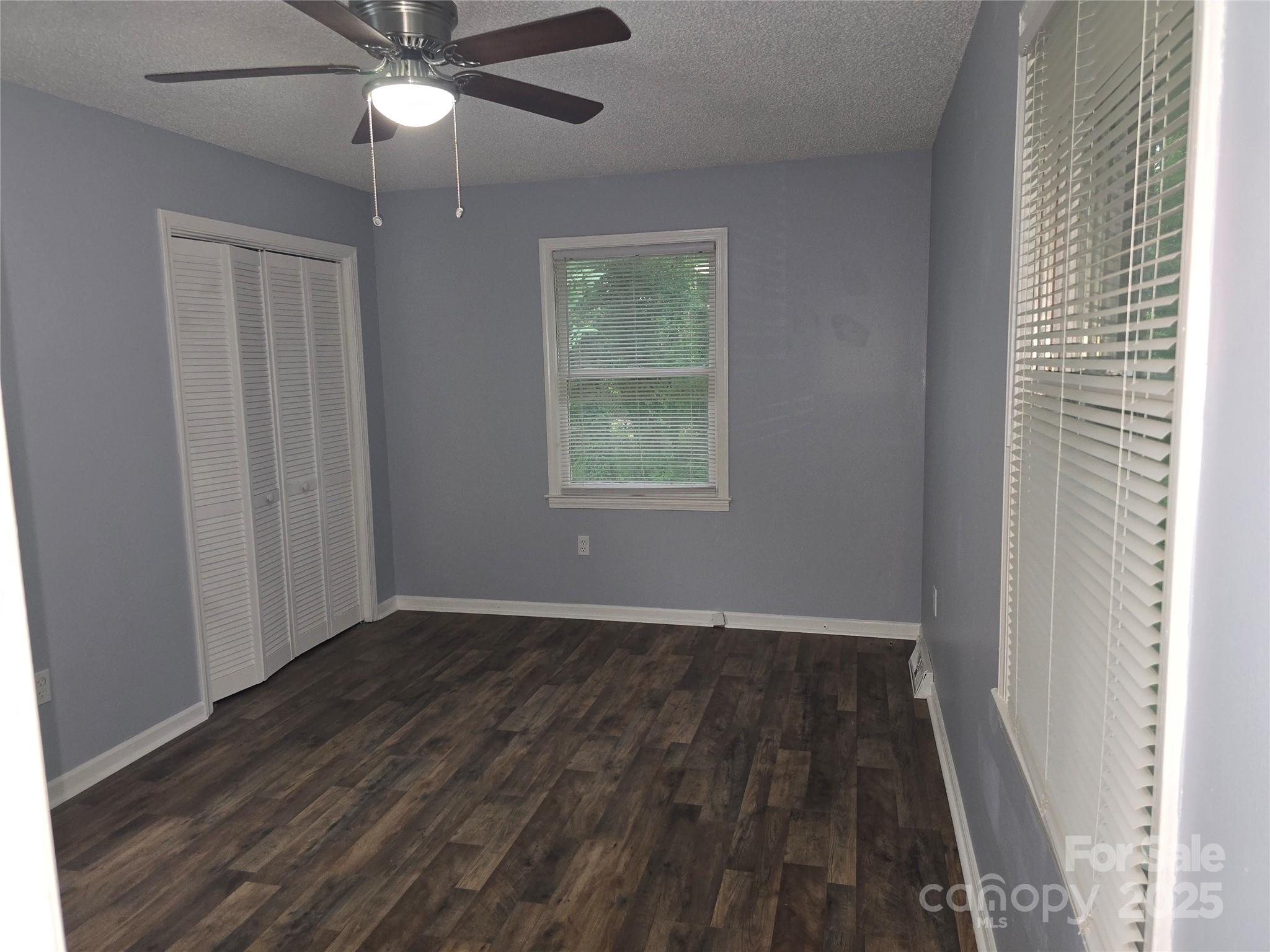 1660 Songwood Road Concord, NC 28025 - Photo 20 of 32 an empty room with wooden floor fan and windows
