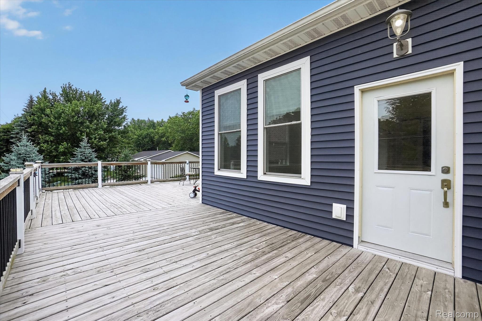 6524 Kelly Road Flushing, MI 48433 - Photo 43 of 47 Spacious outdoor deck featuring wood decking, white railing posts, and black balusters
