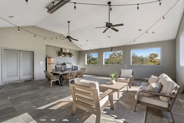 a living room with patio furniture and a ceiling fan