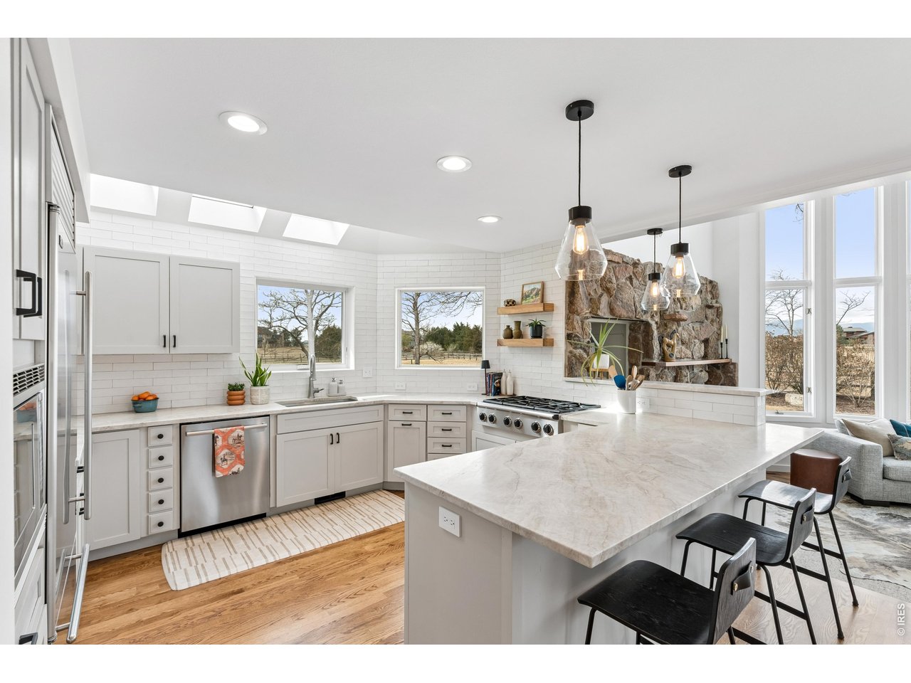 9421 Gunbarrel Ridge Road Boulder, CO 80301 - Photo 13 of 50 a kitchen with stainless steel appliances granite countertop a stove a sink dishwasher and a refrigerator with wooden floor