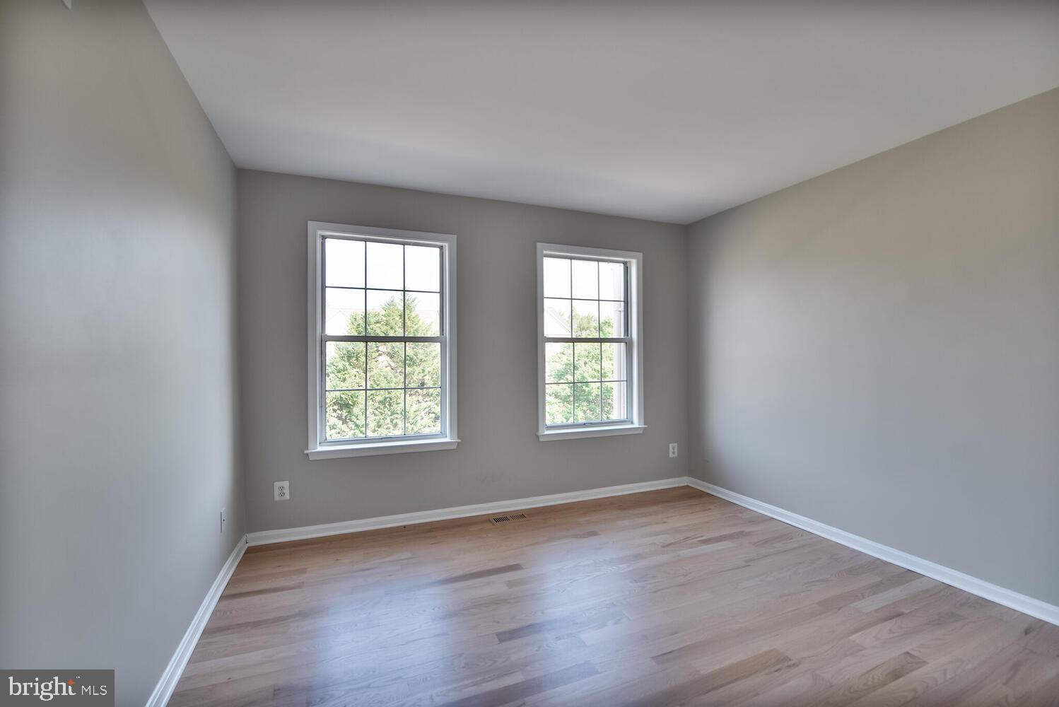 20881 Trinity Square Sterling, VA 20165 - Photo 19 of 35 an empty room with wooden floor and windows