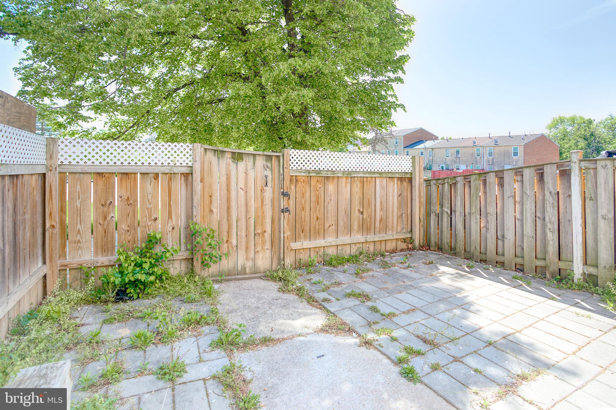 819 Aisquith Street Baltimore, MD 21202 - Photo 11 of 26 a backyard of a house with plants and trees with wooden fence