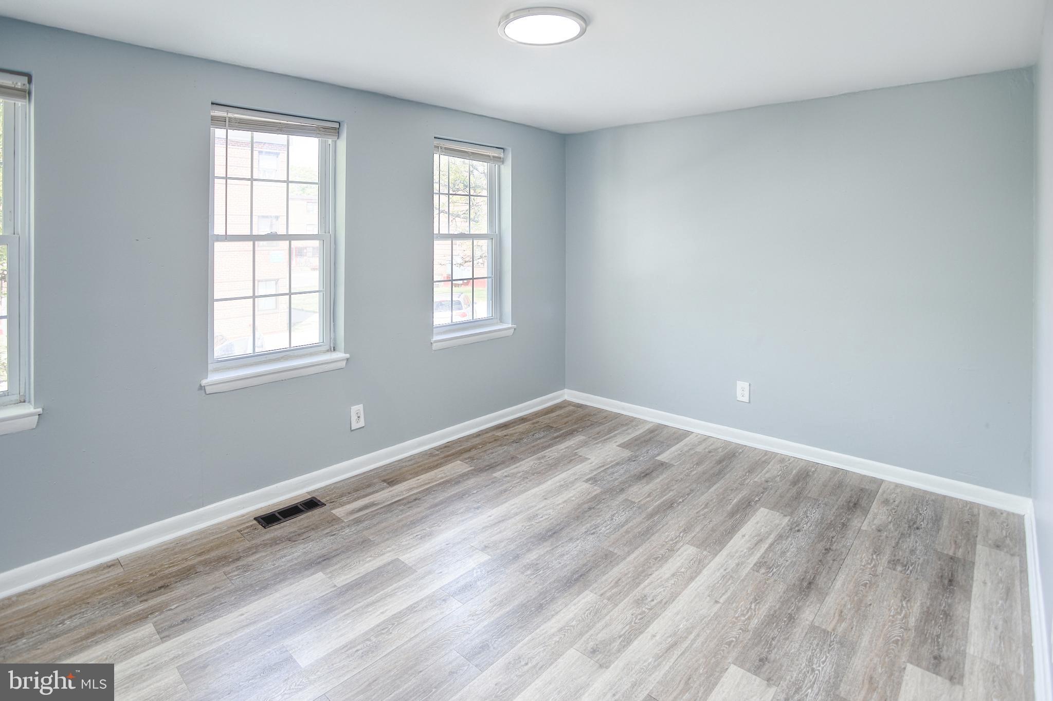 819 Aisquith Street Baltimore, MD 21202 - Photo 18 of 26 an empty room with wooden floor and windows