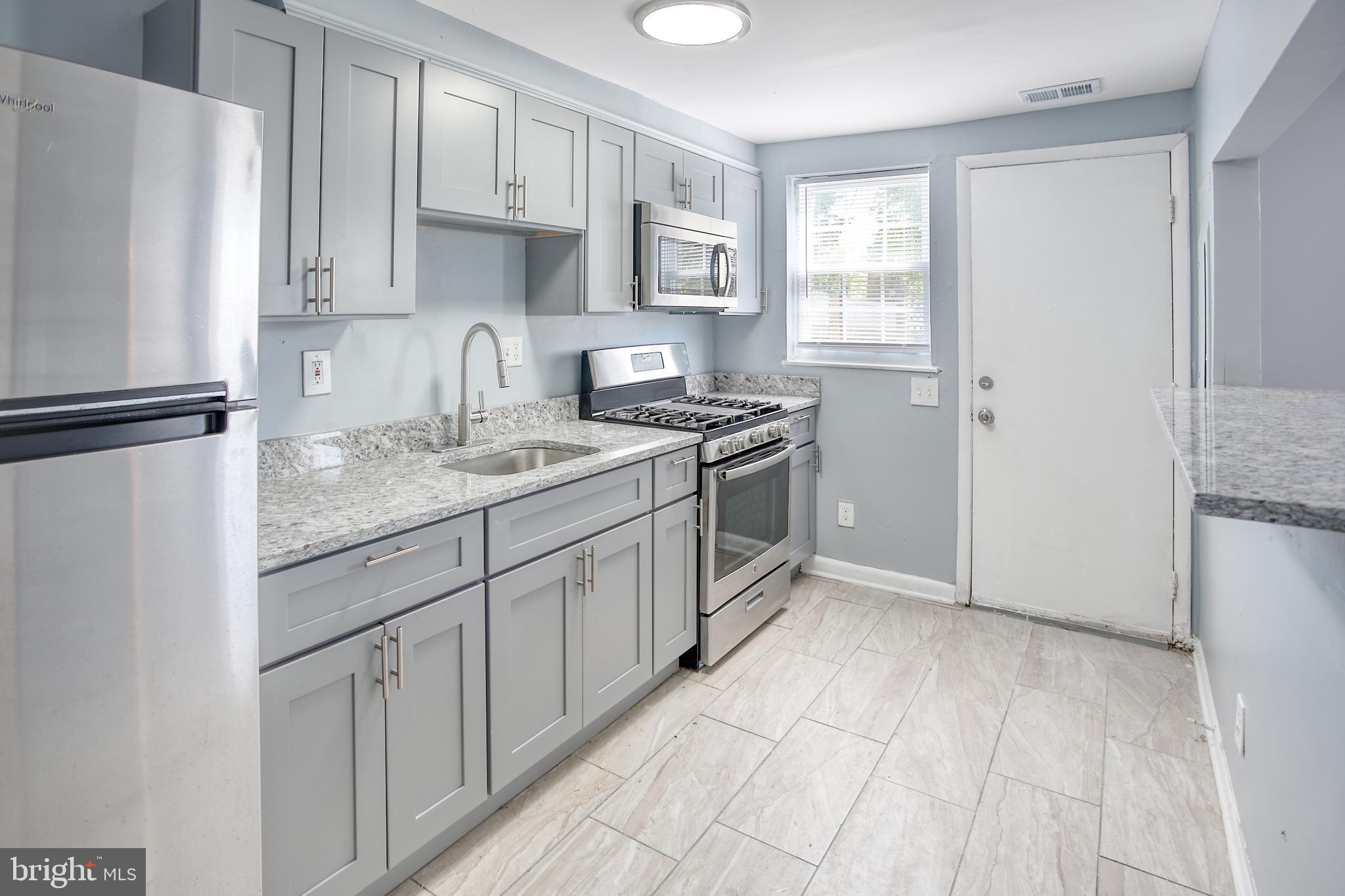 819 Aisquith Street Baltimore, MD 21202 - Photo 6 of 26 a kitchen with stainless steel appliances granite countertop a refrigerator sink and stove